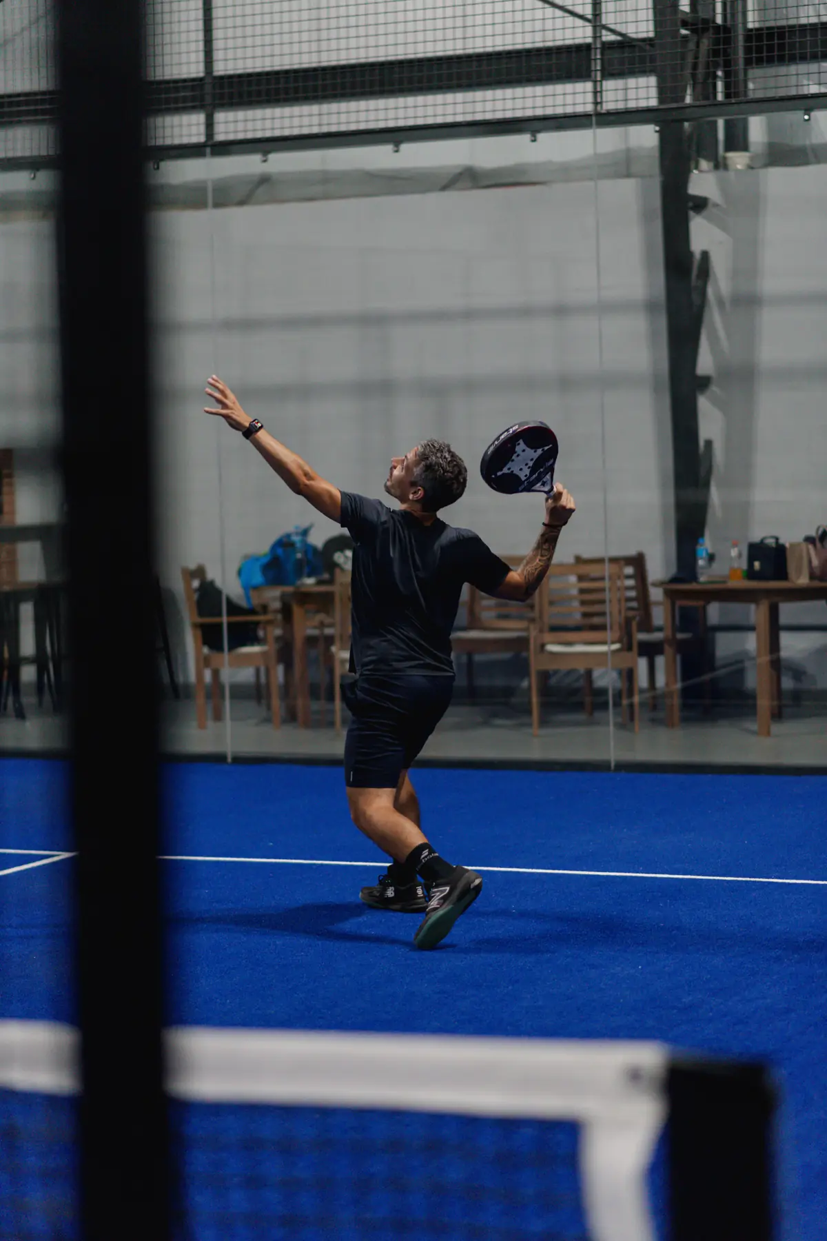 Jogador sacando numa quadra do PadelRJ